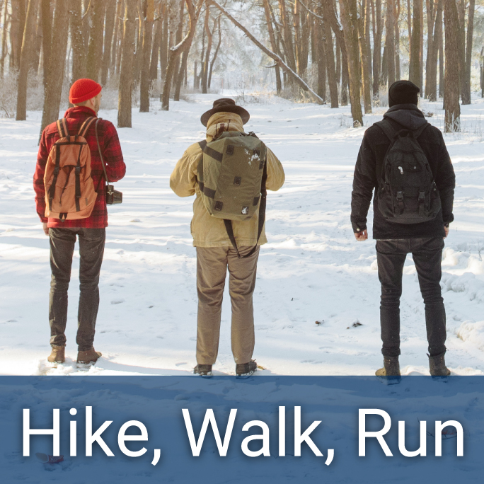 Three adult male hikers stand on a snowy road that cuts through a snowy forest, header reads "Hike, Walk, Run"