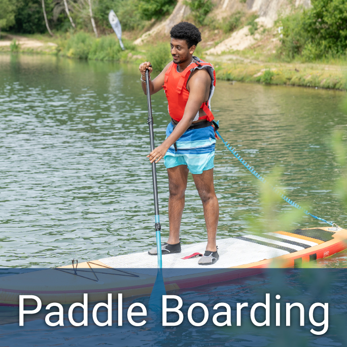 young african american male paddle boarding on a lake; lower header reads: Paddle Boarding