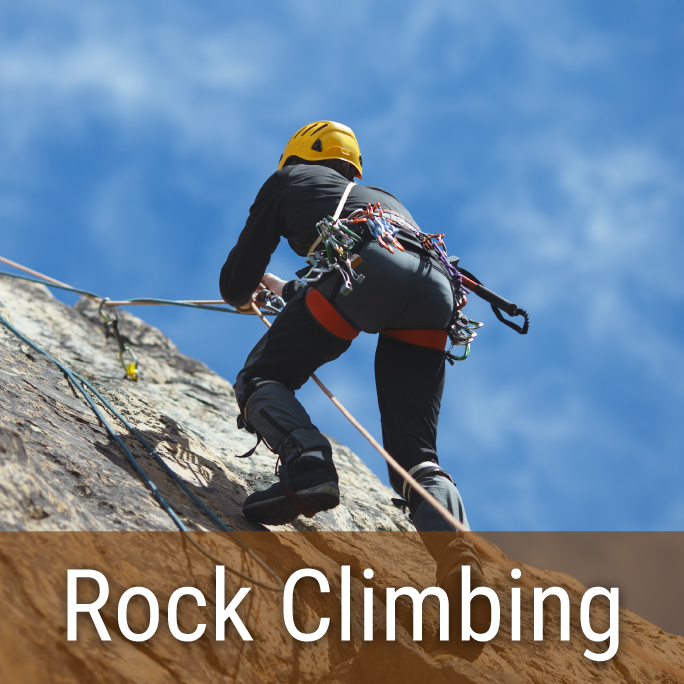 man rock climbing with a yellow helmet